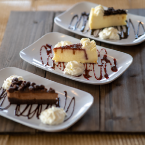 Three slices of cake on plates with chocolate drizzle at Ropewalk OC