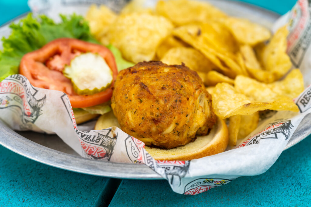 A crabcake sandwich with chips on the side.