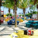 Colorful tables outside on the sand.