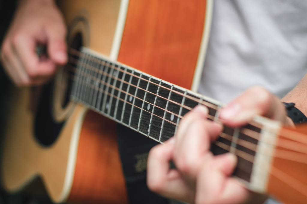 Person's hands playing a guitar