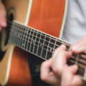 Person's hands playing a guitar